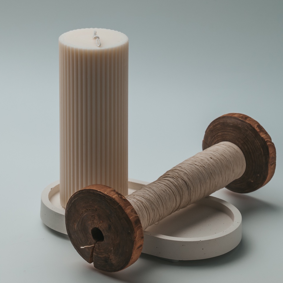 Ribbed candle and vintage wooden spool on a decorative tray – photography by Filip Labanc for No Smile Needed