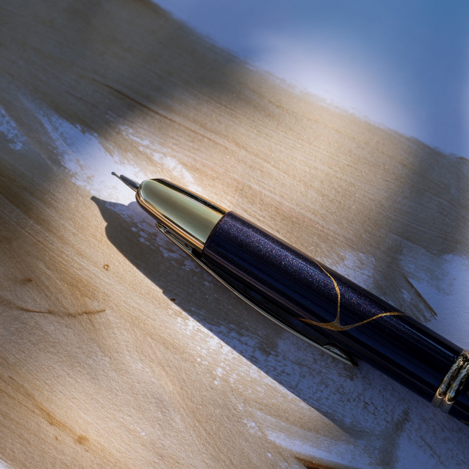 Blue and gold fountain pen on textured paper in directional light – photography by Filip Labanc for No Smile Needed